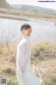 A woman in a white dress standing in a field.