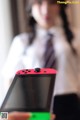 A woman holding a red Nintendo Switch in her hands.