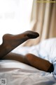 A woman laying on a bed with her feet up.