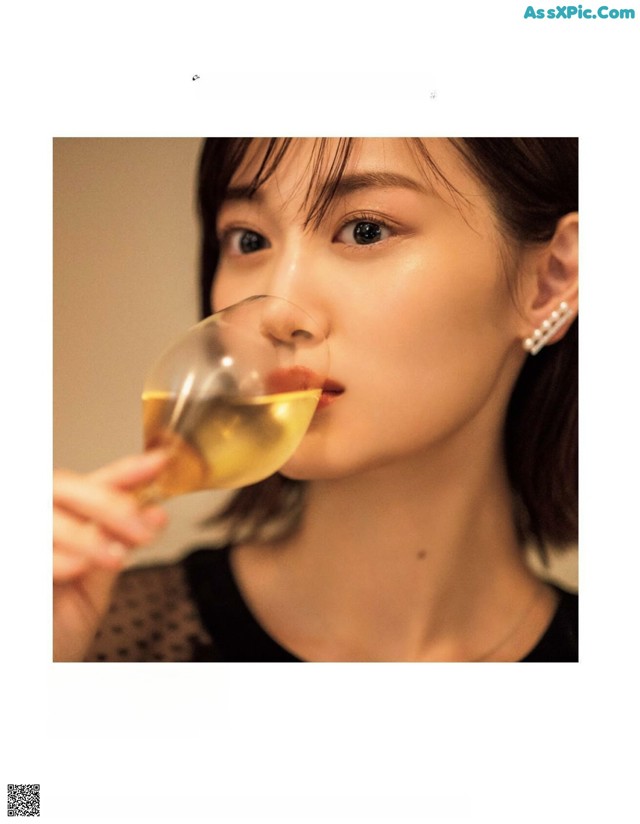 A woman drinking a glass of white wine.