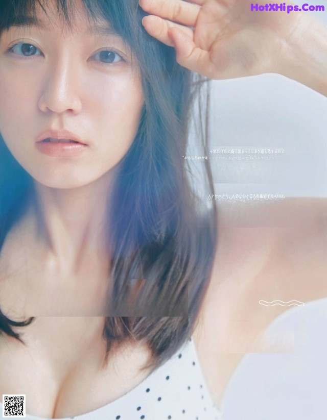 A woman with long black hair is posing for a magazine.
