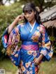 A woman in a blue and pink kimono posing for a picture.