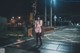 A woman in lingerie standing on a train track at night.