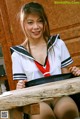 A woman in a school uniform sitting at a table.