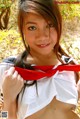 A woman in a school uniform holding a red scarf.