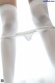 A close up of a woman's legs in white stockings.