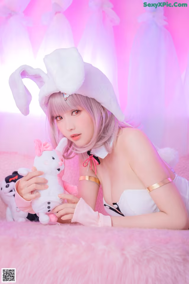 A woman in a bunny costume holding a stuffed animal.