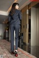 A woman in a business suit standing in a hallway.