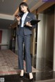 a woman in a business suit standing in an elevator