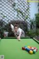 A woman is playing a game of pool. 