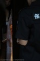 A woman in a police uniform standing in front of a door.