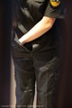 A woman in a police uniform is standing with her hands in her pockets.