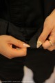 A woman wearing a black shirt and a gold ring.