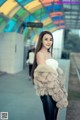 A woman in a fur coat standing on a train platform.