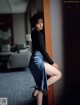 A woman leaning against a wall in a hotel room.