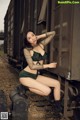 A woman in a green bikini sitting on a train.