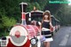 A woman standing in front of a red and white train.