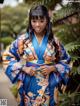 A woman in a blue and yellow kimono posing for a picture.