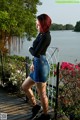 A woman standing on a wooden deck next to a body of water.