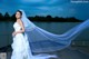 A woman in a wedding dress standing on a dock.